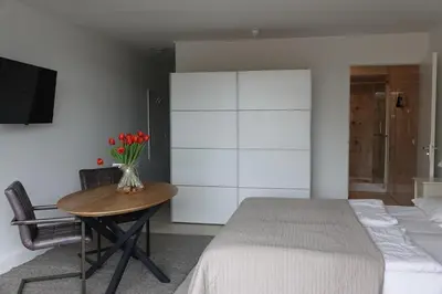 a bedroom with a bed and a table with flowers on it at Huize de Duinen in Bergen aan Zee