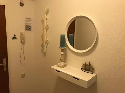 a mirror and a candle on a shelf in a room at Sterflat 59 in Egmond aan Zee