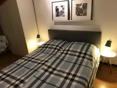 a bedroom with a bed with two lights on at Sterflat 59 in Egmond aan Zee