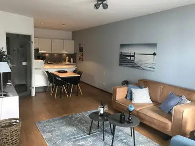 a living room with a couch and a table at Sterflat 59 in Egmond aan Zee
