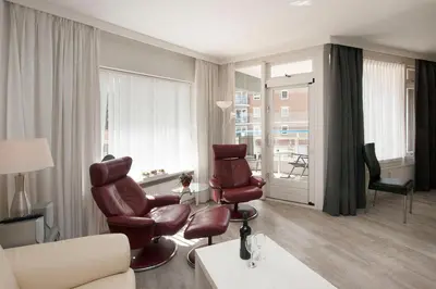 a living room with two chairs and a window at Sterflat 61 in Egmond aan Zee