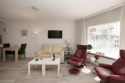 a living room with a couch and chairs and a table at Sterflat 61 in Egmond aan Zee