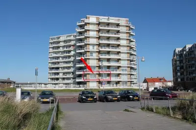 a red arrow on a tall building in a parking lot at Sterflat 65 in Egmond aan Zee