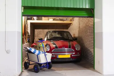 a small car parked inside of a garage at Sterflat 63 in Egmond aan Zee