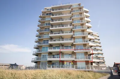 a tall apartment building on the beach at Sterflat 63 in Egmond aan Zee