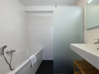 a white bathroom with a tub and a sink at Assum Great in Uitgeest