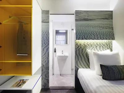a room with a bed and a bathroom with a sink at ibis Styles Amsterdam Central Station in Amsterdam