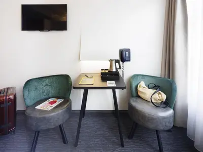 a room with two chairs and a table with a telephone at ibis Styles Amsterdam Central Station in Amsterdam