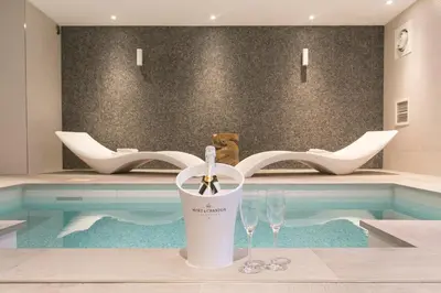 a swimming pool with two wine glasses on a table at Van der Valk Hotel Akersloot / A9 ALKMAAR in Akersloot