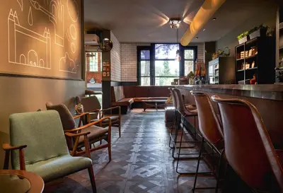 a bar with a row of chairs and a counter at Max Brown Hotel Museum Square, part of Sircle Collection in Amsterdam