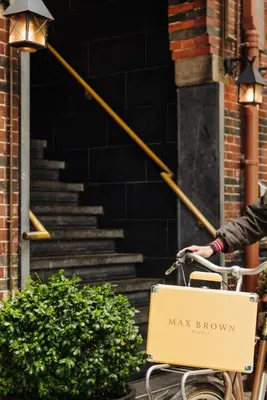 a person riding a bike with a box on the front at Max Brown Hotel Museum Square, part of Sircle Collection in Amsterdam