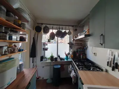 a small kitchen with a stove and a window at Appartement met 2 slaapkamers en tuin in Amsterdam in Amsterdam