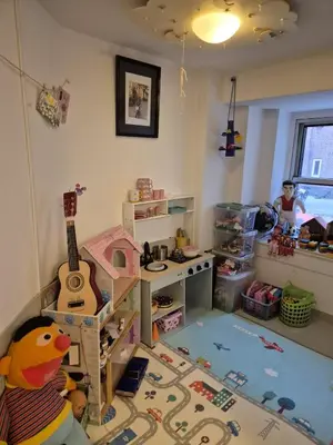 a childs room with a toy kitchen and a guitar at Appartement met 2 slaapkamers en tuin in Amsterdam in Amsterdam