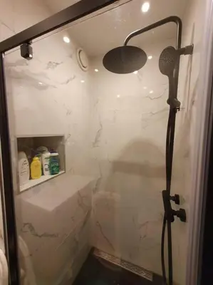a shower in a bathroom with a glass door at Appartement met 2 slaapkamers en tuin in Amsterdam in Amsterdam