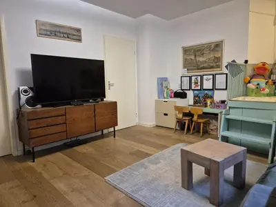 a living room with a flat screen tv on a dresser at Appartement met 2 slaapkamers en tuin in Amsterdam in Amsterdam