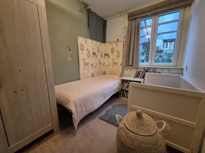 a small bedroom with a bed and a window at Appartement met 2 slaapkamers en tuin in Amsterdam in Amsterdam