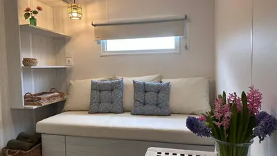 a bench in a room with pillows and a window at Glamping de Hof van Eeden in Warmond