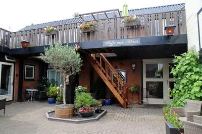 a building with a balcony with plants on it at Hofje van Maas in Zandvoort
