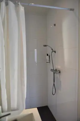 a bathroom with a shower with a shower curtain at Hofje van Maas in Zandvoort