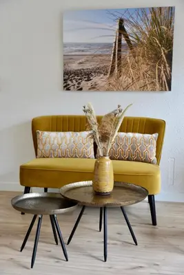 a living room with a yellow couch and a table at Hofje van Maas in Zandvoort