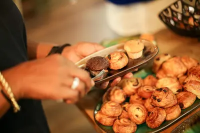 a person holding a tray of pastries on a table at Hotel Heemskerk in Heemskerk