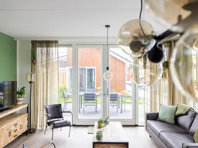 a living room with a couch and a table at Holiday Home De Meerparel by Interhome in Uitgeest