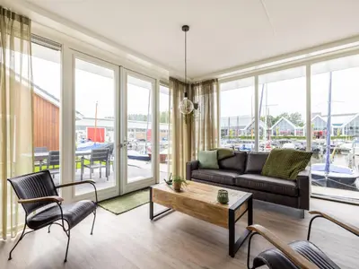 a living room with a couch and a table at Holiday Home De Meerparel by Interhome in Uitgeest