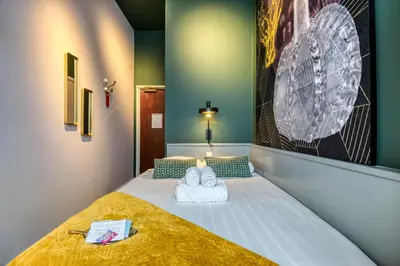 a room with a bed with two towels on it at Hotel Alexander in Amsterdam