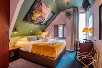 a hotel room with a bed and a table and a chair at Hotel Alexander in Amsterdam