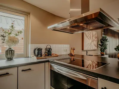 a kitchen with a stove top oven next to a window at Houseboat in Netherlands with Private Dock in Uitgeest