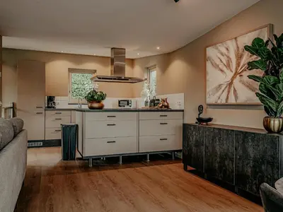 an open kitchen with white cabinets and a couch at Houseboat in Netherlands with Private Dock in Uitgeest