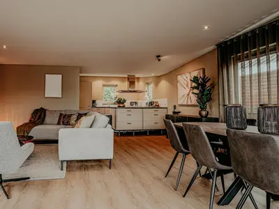 a living room with a couch and a table and chairs at Houseboat in Netherlands with Private Dock in Uitgeest