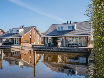 a row of houses on a body of water at Houseboat in Netherlands with Private Dock in Uitgeest