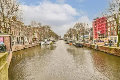 a river in a city with houses and buildings at Amsterdam Alley Apartment in Amsterdam
