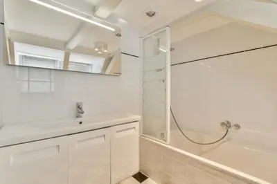 a white bathroom with a sink and a shower at Amsterdam Alley Apartment in Amsterdam