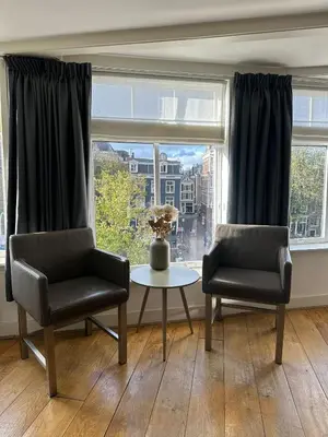 two chairs and a table in front of a window at Amsterdam Alley Apartment in Amsterdam