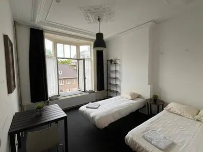 a room with two beds and a window at Hotel Galerij in Amsterdam