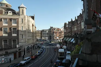 a busy city street with cars parked on the road at Hotel Galerij in Amsterdam