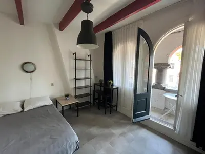 a bedroom with a bed and a room with a window at Hotel Galerij in Amsterdam
