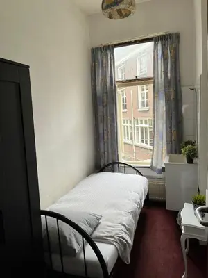 a bed in a room with a window at Hotel Galerij in Amsterdam