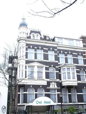 a black and white building with a clock tower at Owl Hotel in Amsterdam