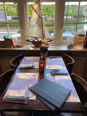 a wooden table with a laptop on top of it at Hotel Café Restaurant Heineke in Loosdrecht