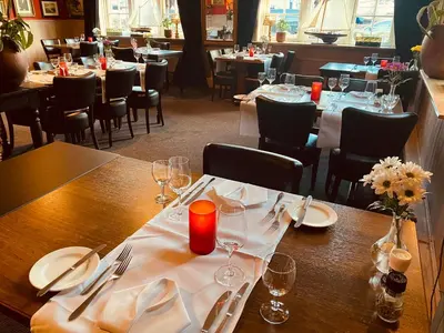 a table in a restaurant with tables and chairs at Hotel Café Restaurant Heineke in Loosdrecht