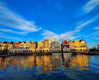 a row of houses on the water near a river at Hotel Café Restaurant Heineke in Loosdrecht
