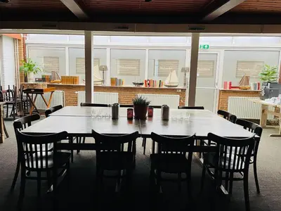 a large table and chairs in a room at Hotel Café Restaurant Heineke in Loosdrecht