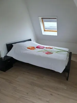 a bed with a white comforter and a window at Mathildahoeve in Warder