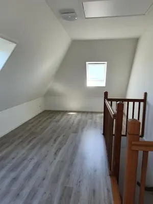 an attic room with a staircase and a window at Mathildahoeve in Warder
