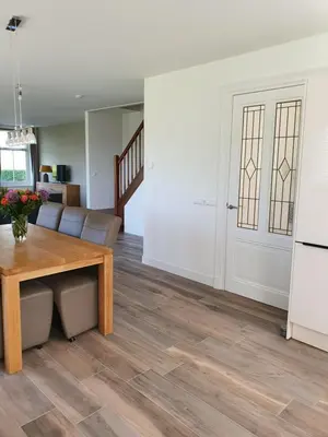 a living room with a wooden table and a kitchen at Mathildahoeve in Warder