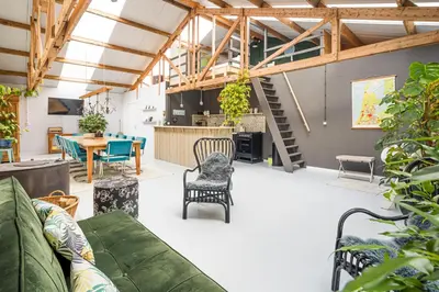a living room with a green couch and chairs at Het Kamphuis, landelijk slapen in Heerhugowaard