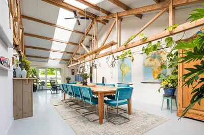 a dining room with a table and blue chairs at Het Kamphuis, landelijk slapen in Heerhugowaard